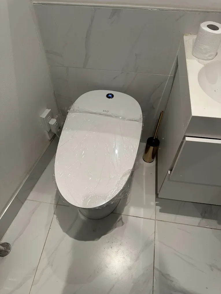 A clean modern bathroom with a new white toilet installed